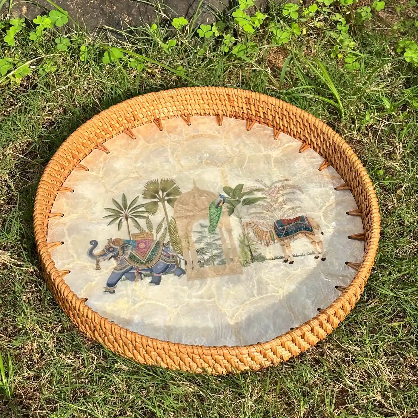 Royal Oasis mother-of-pearl tray with rattan rim photographed outdoors on grass
