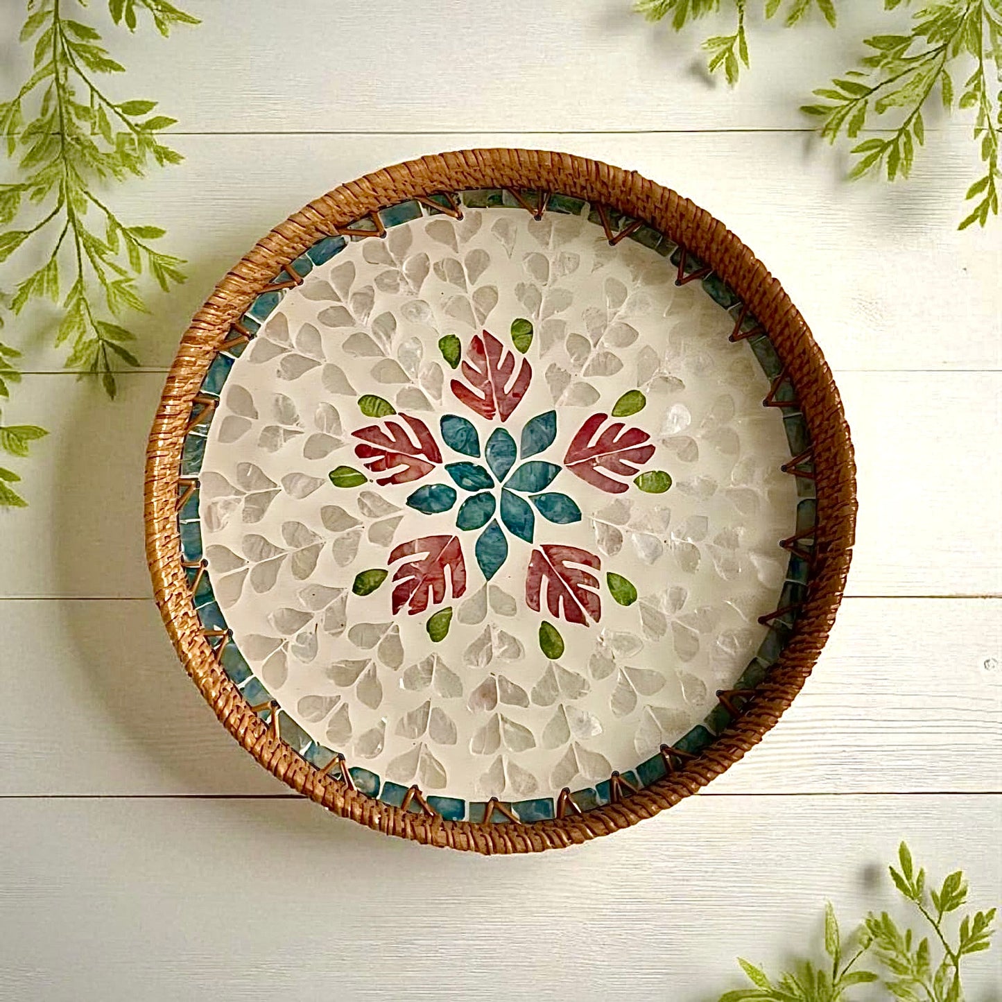 Mother-of-pearl round tray on light wooden surface with soft natural light and leaf shadows