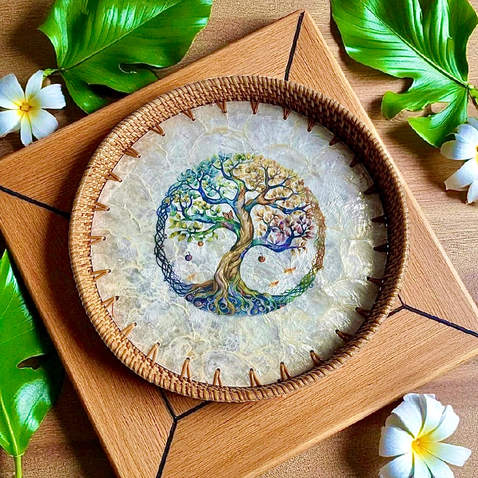 Tree of Life round tray styled on stacked wooden boxes with white flowers and greenery
