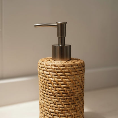 Close-up of the Natural Rattan Soap Dispenser showing the handwoven rattan texture and metal pump
