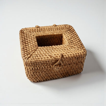 Square handwoven rattan tissue box cover on an off white background