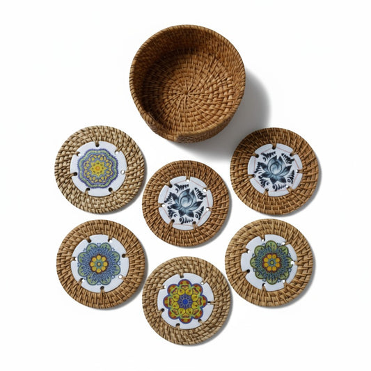 Set of six round rattan coasters with matching woven holder on white background