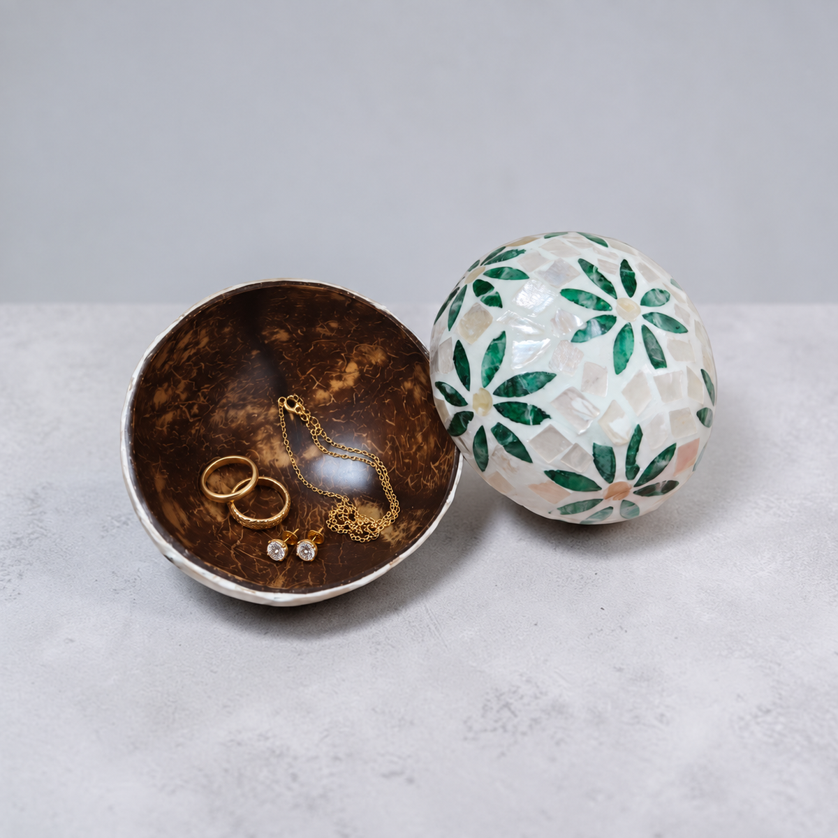 Green Daisy coconut bowl holding rings, earrings and a necklace