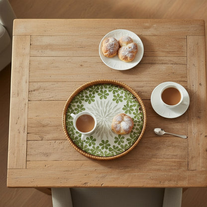 Round mother-of-pearl tray on a wooden table with coffee and buns – breakfast or hosting setup.