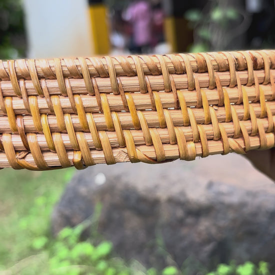 Close-up of the hand-woven rattan rim detail on the round decorative tray.